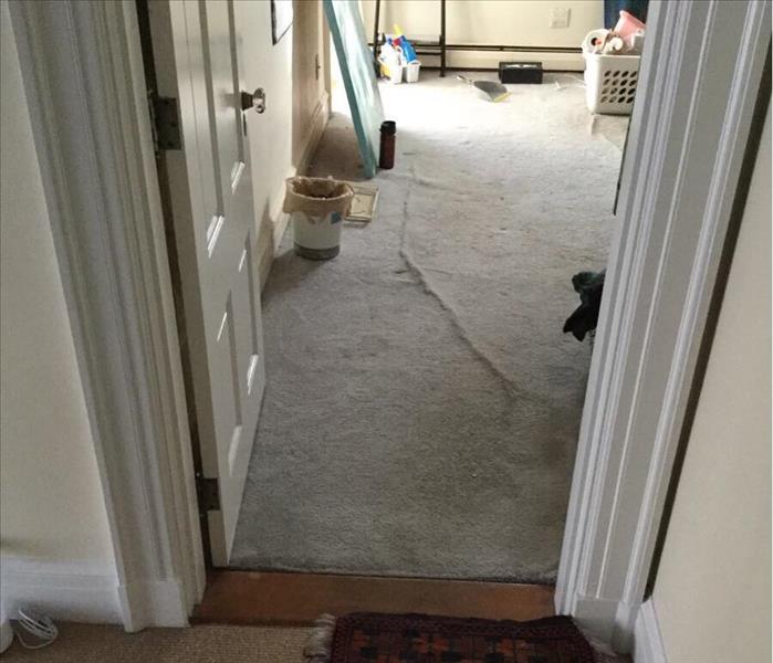 View through doorway into room with water damaged carpet