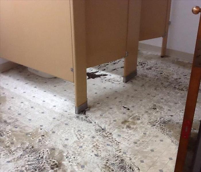 Dirty and heavily damaged public bathroom floor
